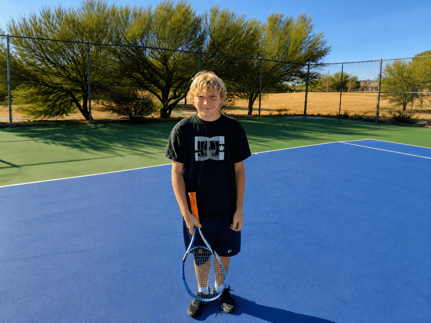 High school tennis player standing on court