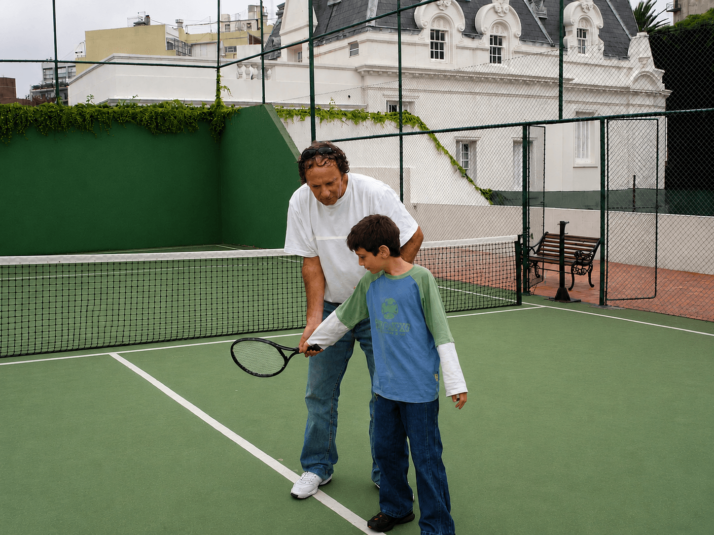 Earlier tennis students standing at the net